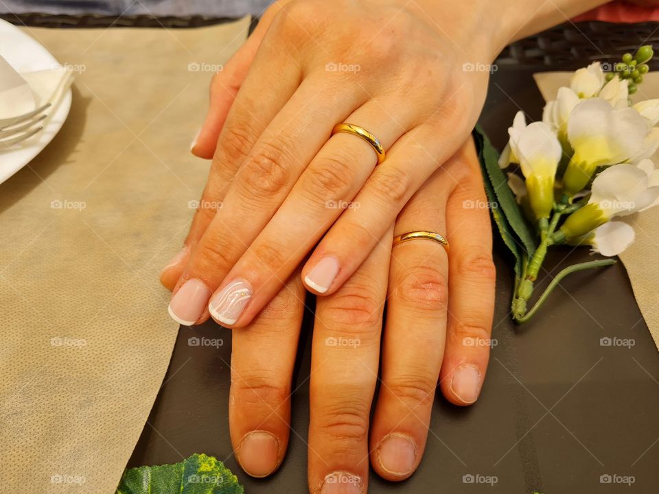 hands of two newlyweds showing wedding rings