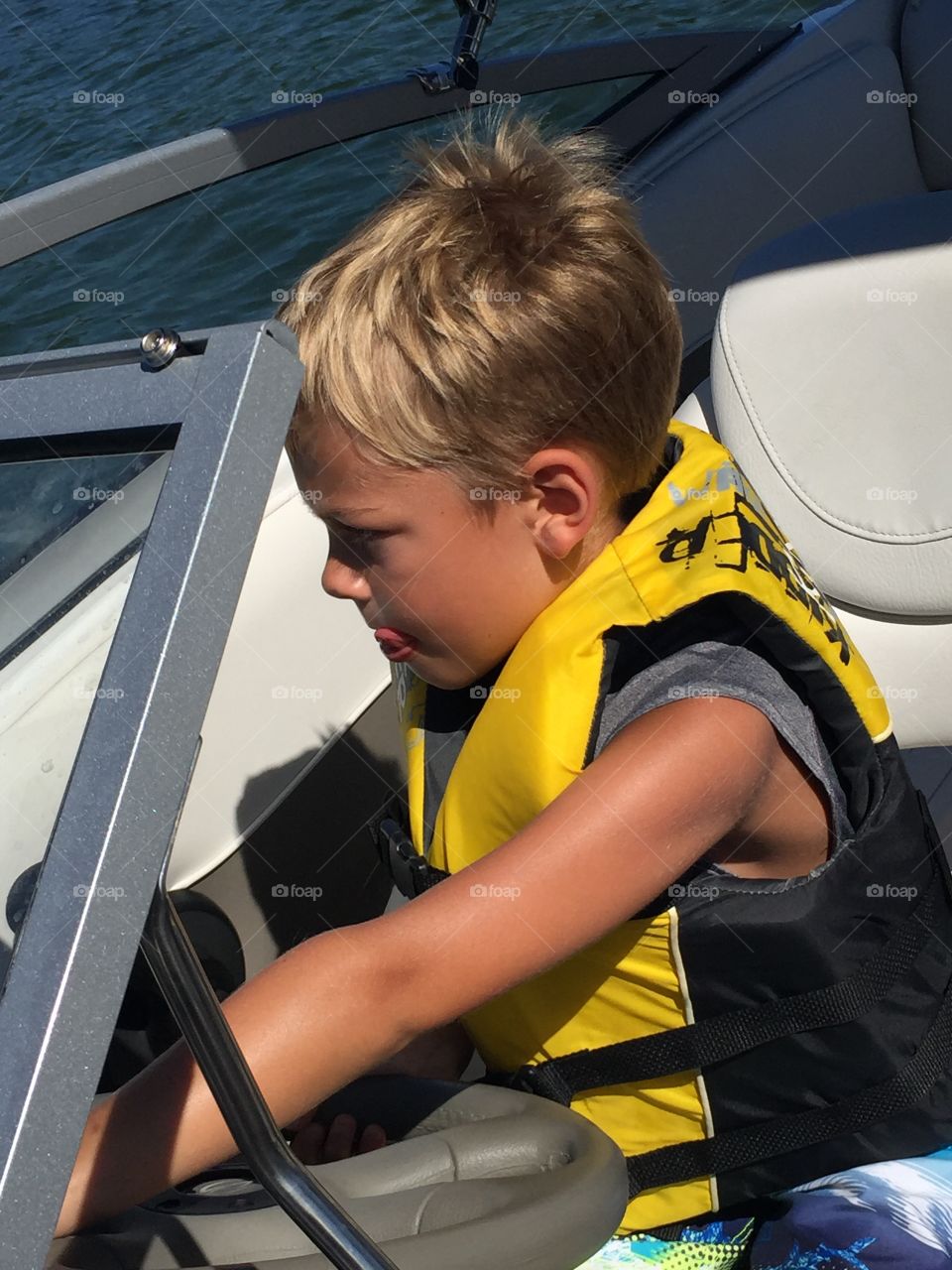 Daddy Let Me Drive. My grandson driving the boat. He only sticks out his tongue when concentrating