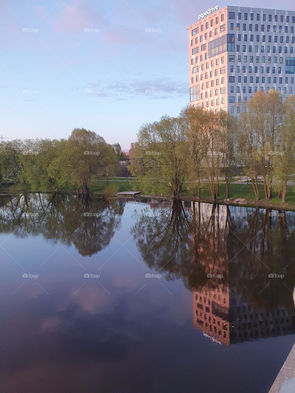 Office building next to a river. This river adds more beauty to a city landscape.