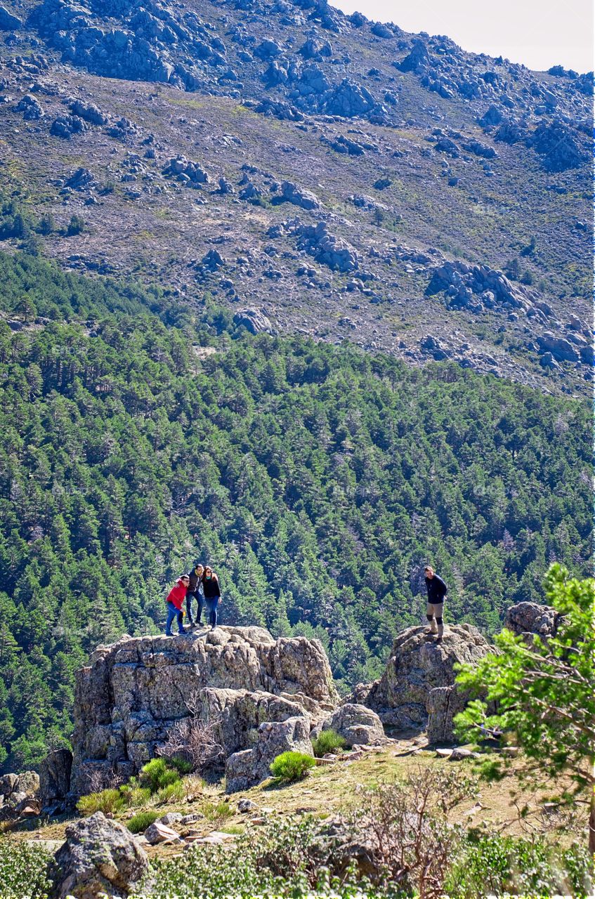 People on top of a rock getting photographed in nature 