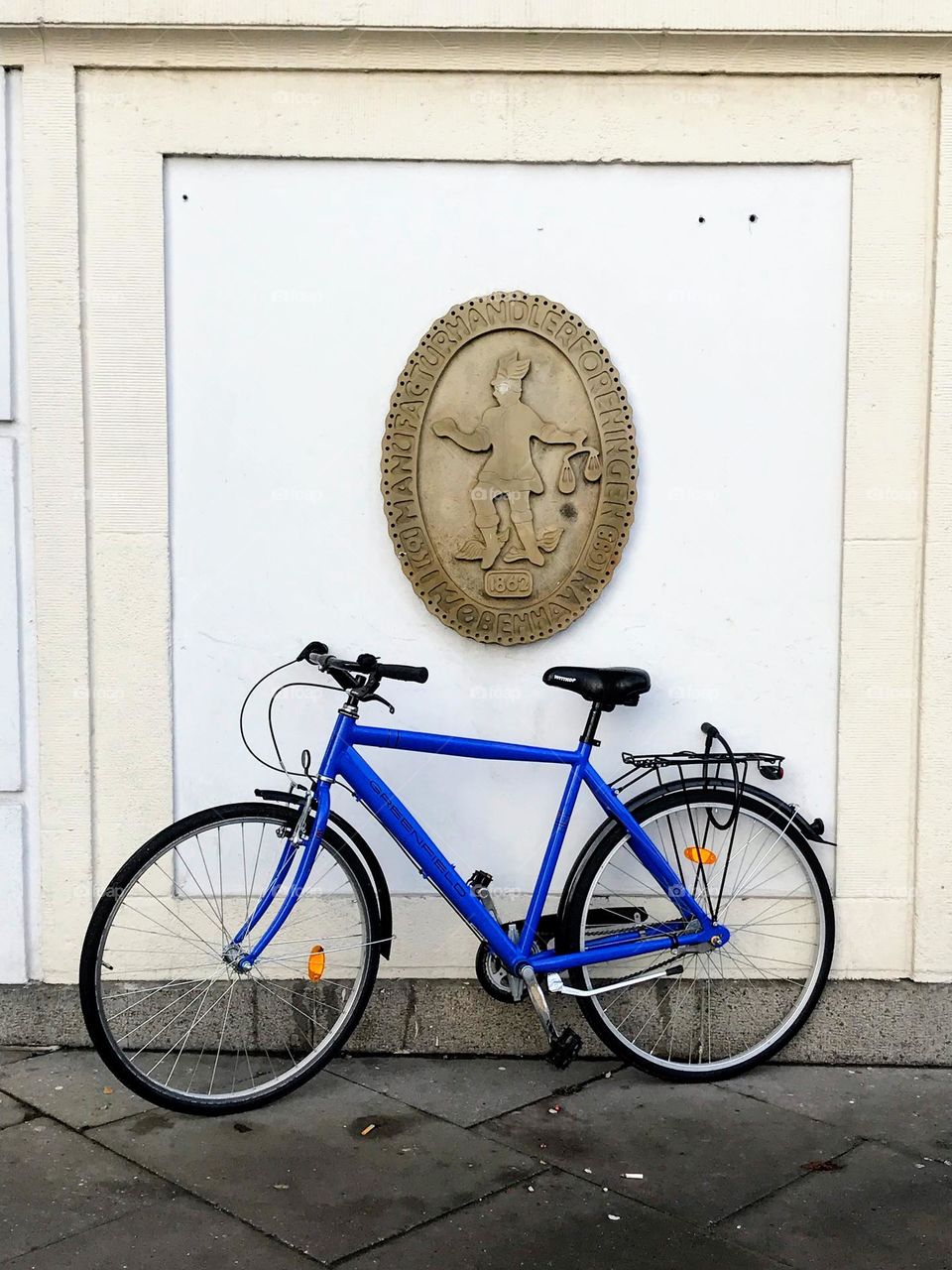 Blue sport bike against the white wall with coat of arms shield on it