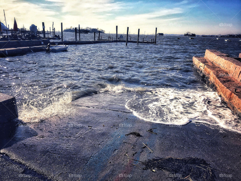 Wind and waves crashing on a boat slip 