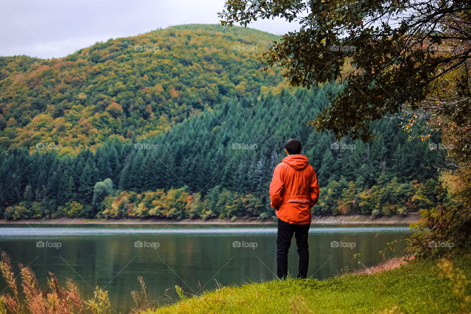 Rear view of man standing at lake 