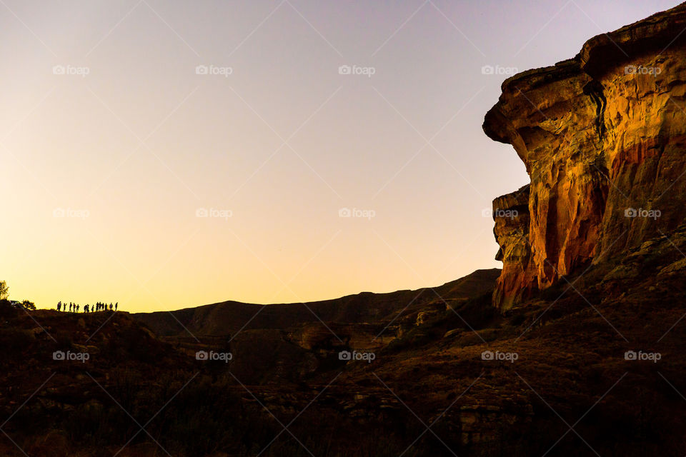 The best mix for day and night photography is at sunset! Love this image of a group of people silhouetted as they admire the majestic sandstone mountains at Golden gate national park in Africa.