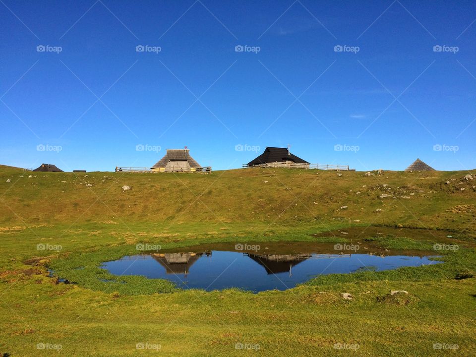 Cottages and the reflection . Cottages and the reflection on a beautiful sunny day on mountain Velika Planina, Slovenia