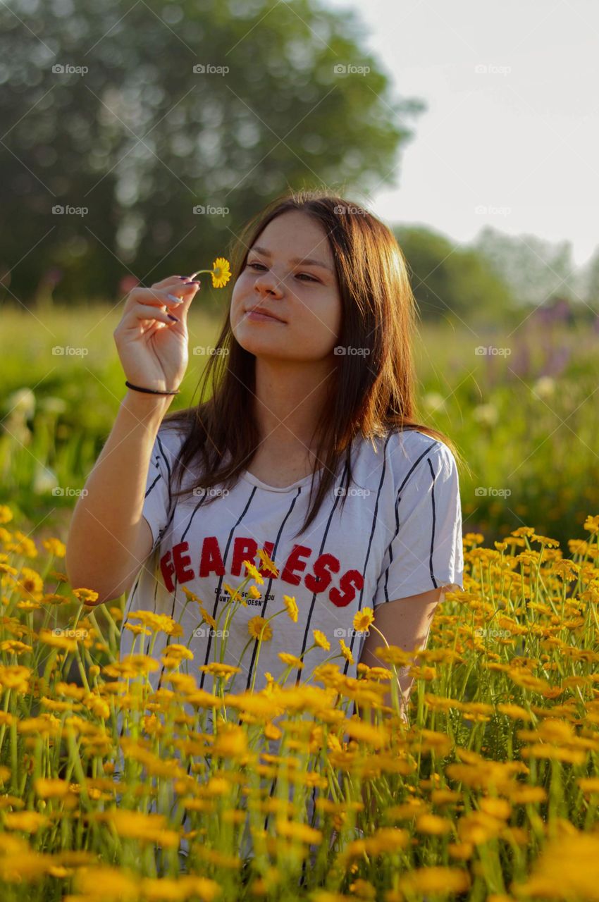 Girl in the field of flowers, engoying the beauty of summer.