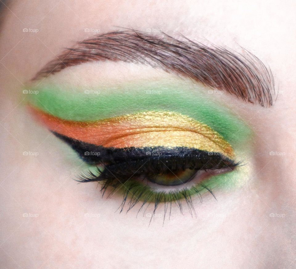 Winged eyeliner, gold make up, orange and green eyeshadows