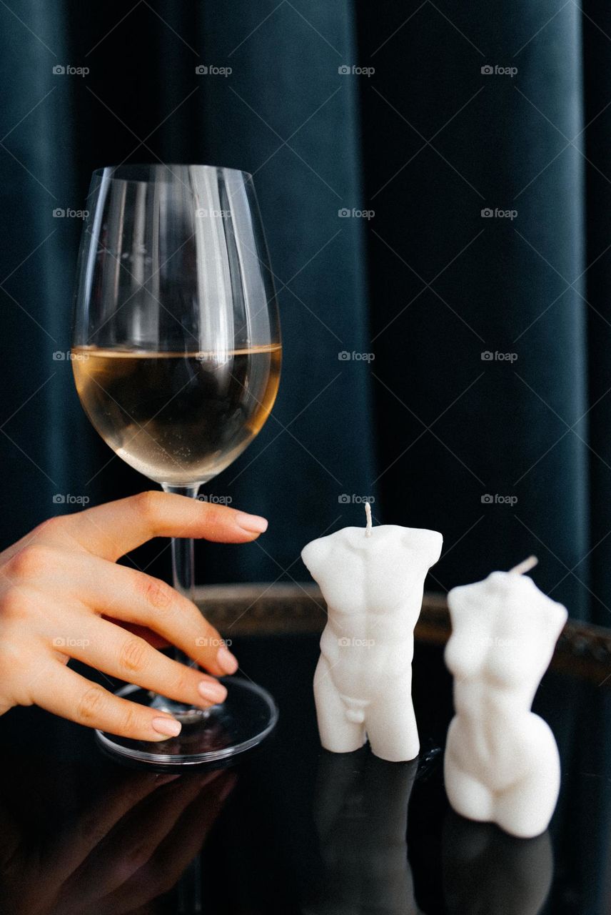 Girl with nude manicure holding a glass of wine