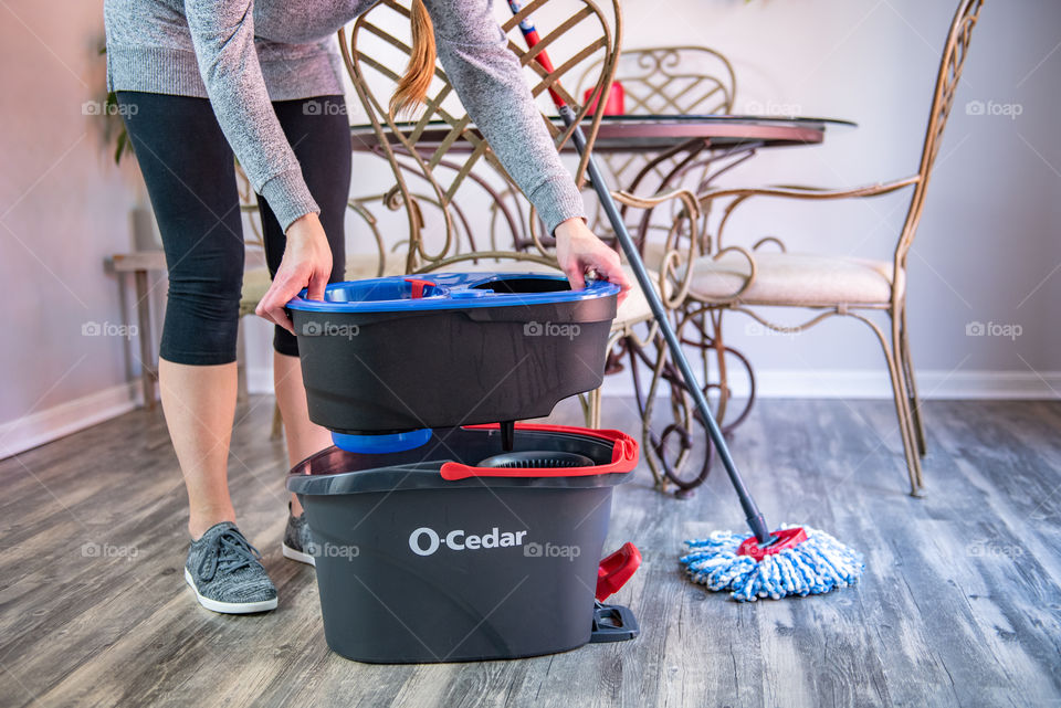 Woman lifting a mop bucket 