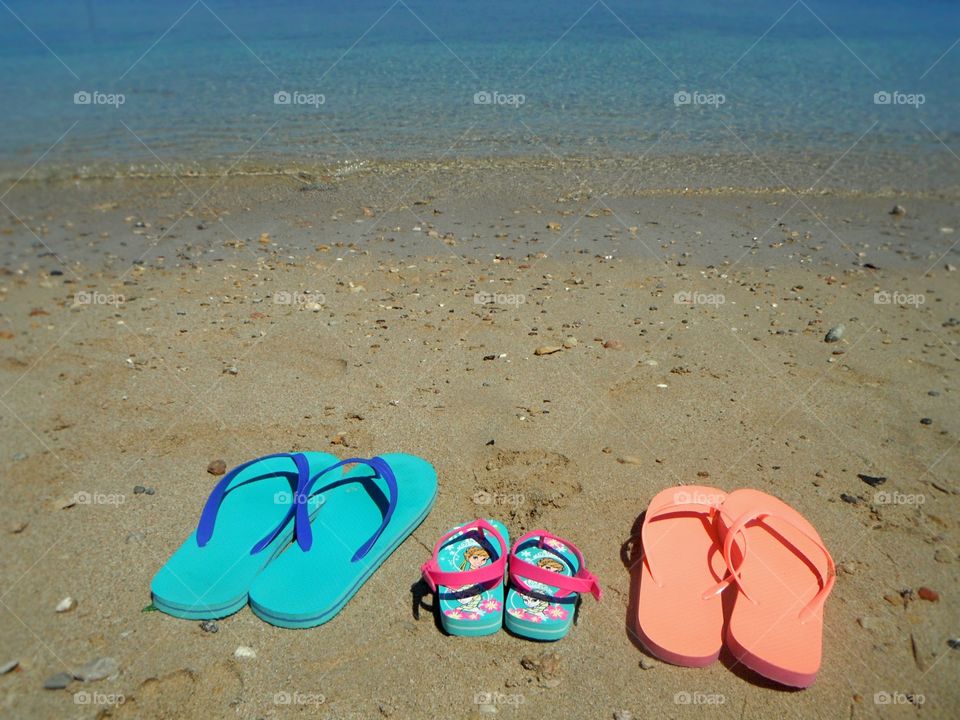 family sandals in front of sea