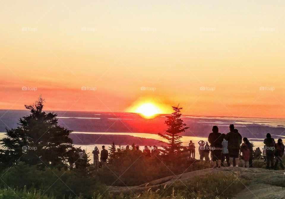 people gather atop Cadillac Mountain in Maine to witness the first light hit the East Coast at sunrise