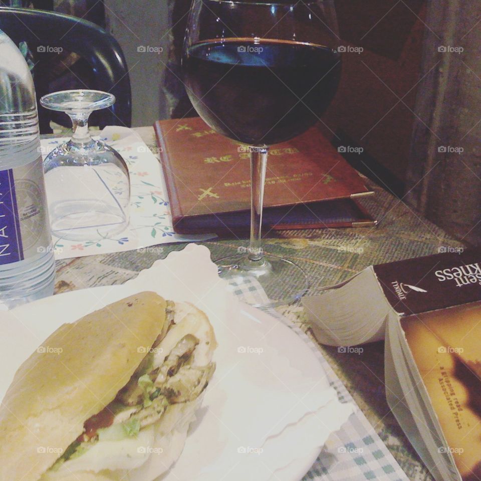 A glass of wine, a simple meal, and a good book while in Rome, Italy.