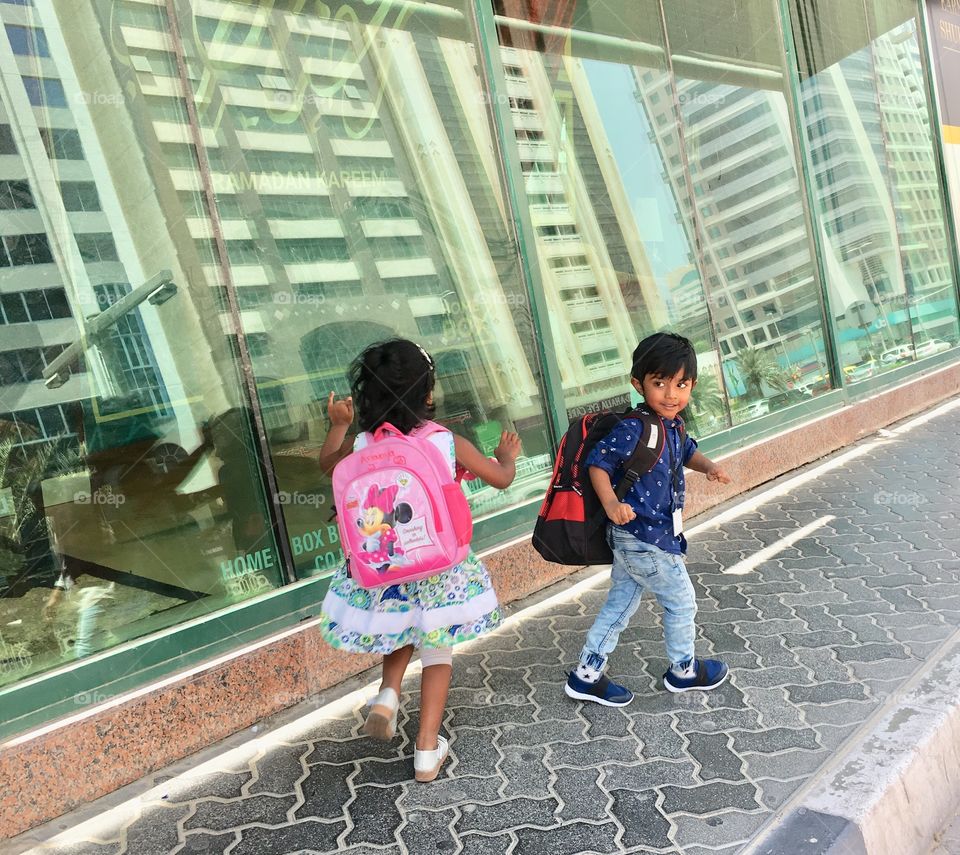 Children running with school bag, enjoying reopening school time, little boy and girl with school bags 