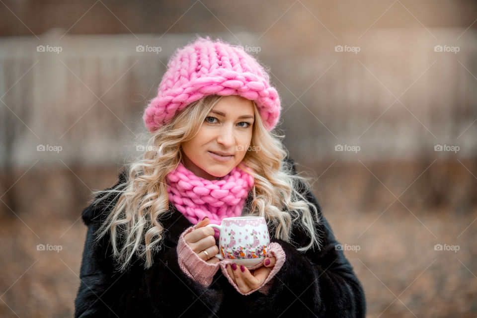 Outdoor Portrait of blonde woman in pink crochet accessories 