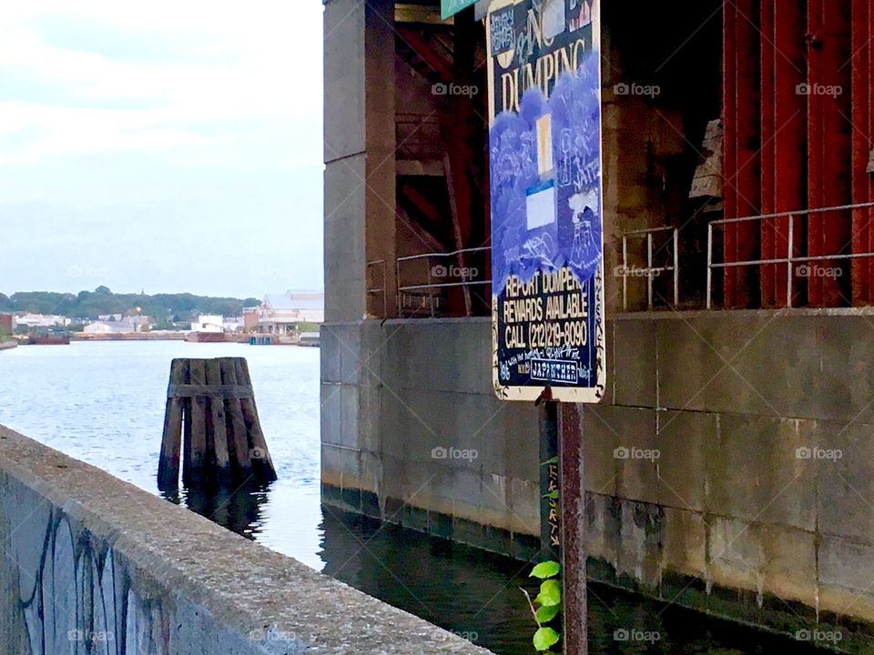 Support pillar of the Pulaski Bridge seen from underneath and the water of the East River in Newtown Creek in Long Island City, Queens, New York. The photograph was taken in the Spring of 2019. Hypnotic Productions