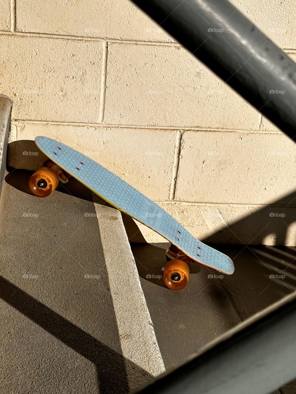 Skateboard nostalgia with a blue poly Kryptonite (since 1965!) short board with urethane wheels on a staircase with metal railings