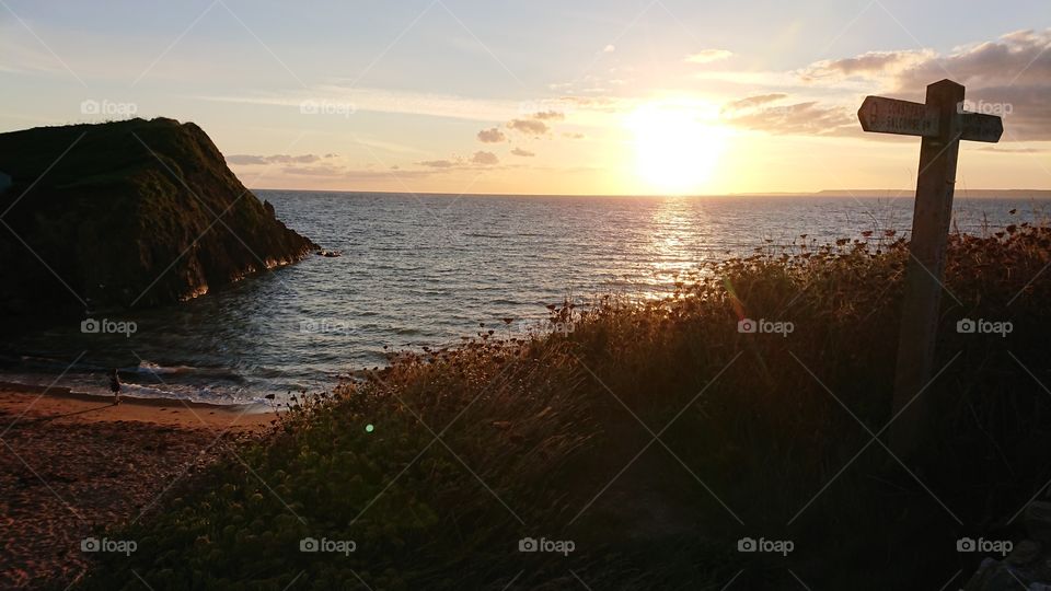 Hope cove south hams Devon England UK sunset over the sea with southwest coast path sign