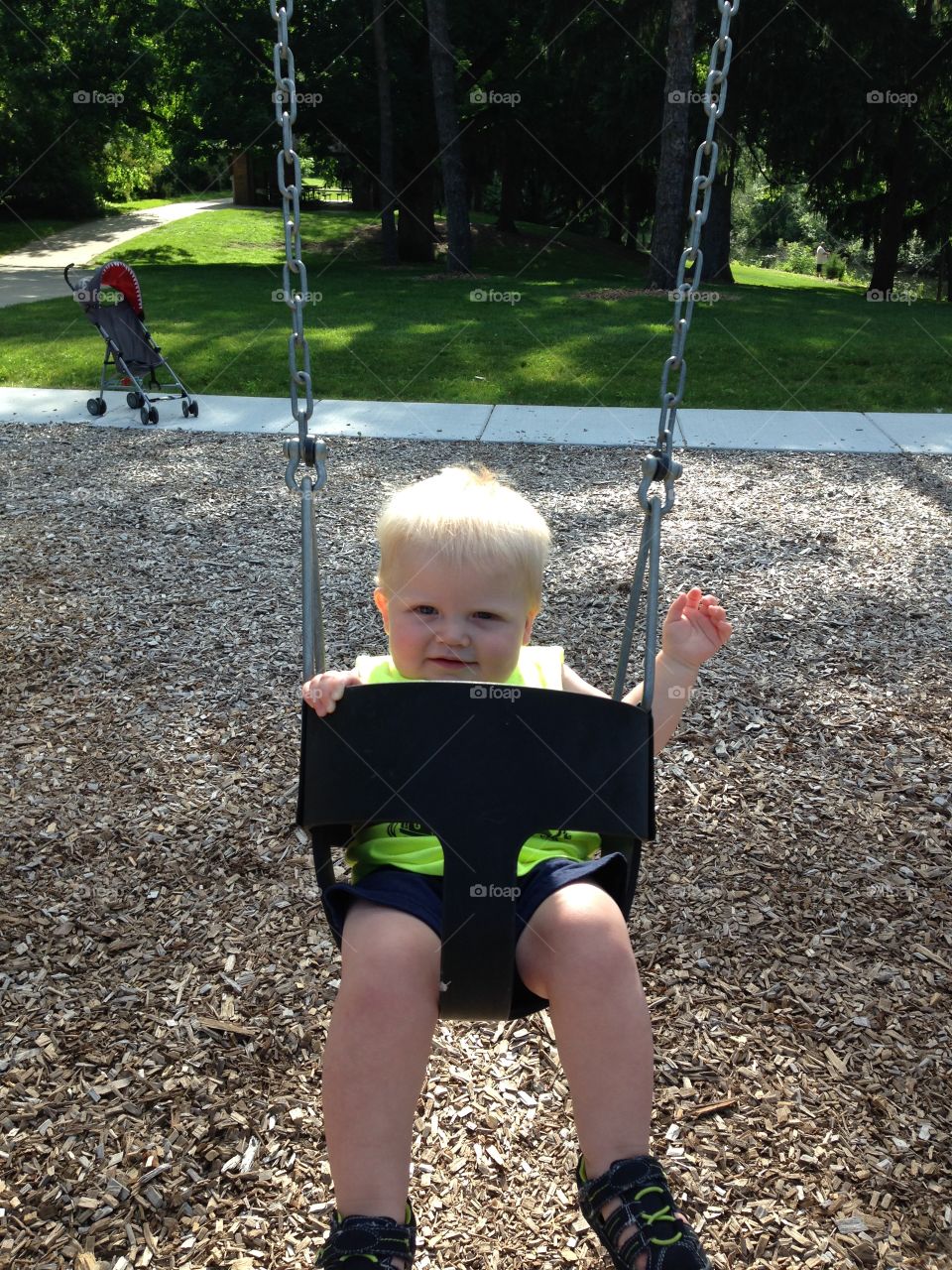 Swinging at the park. Baby swinging at park.