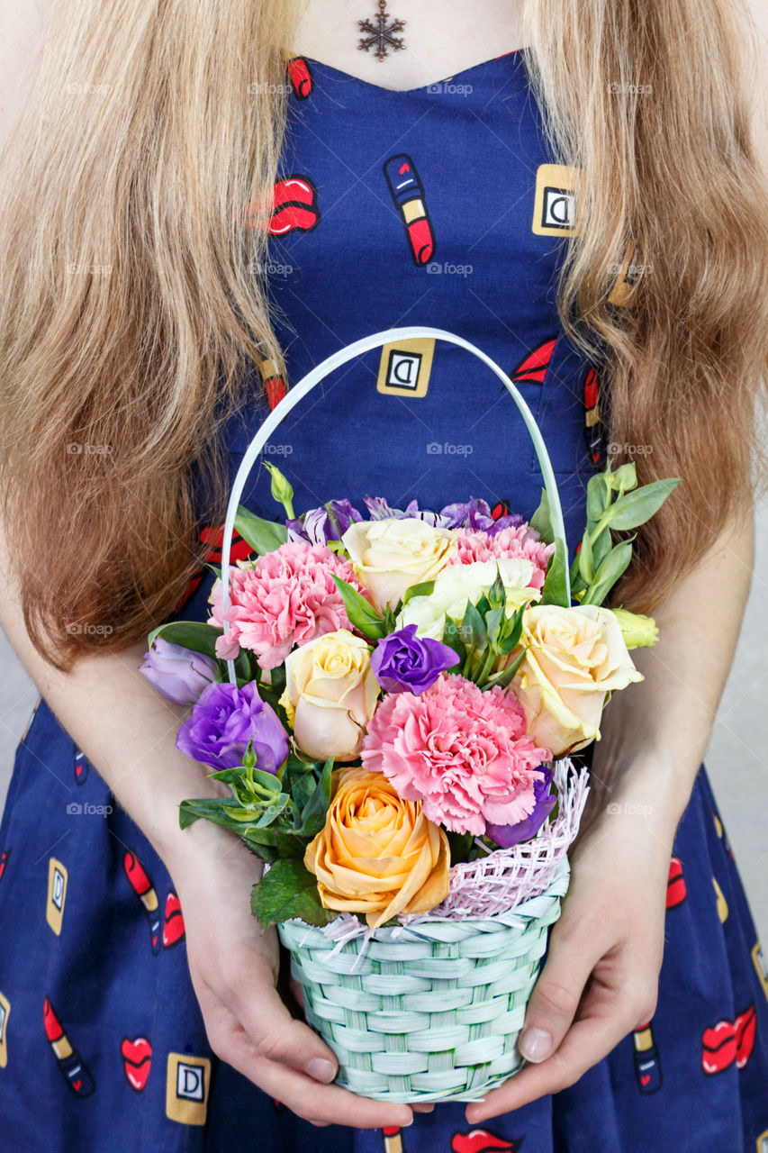 Girl holding flowers basket in hand