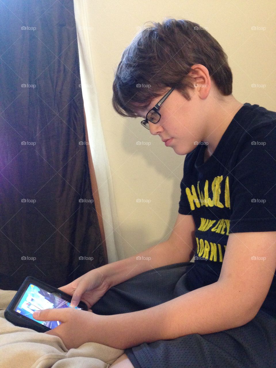 Boy holding iPad and playing a game