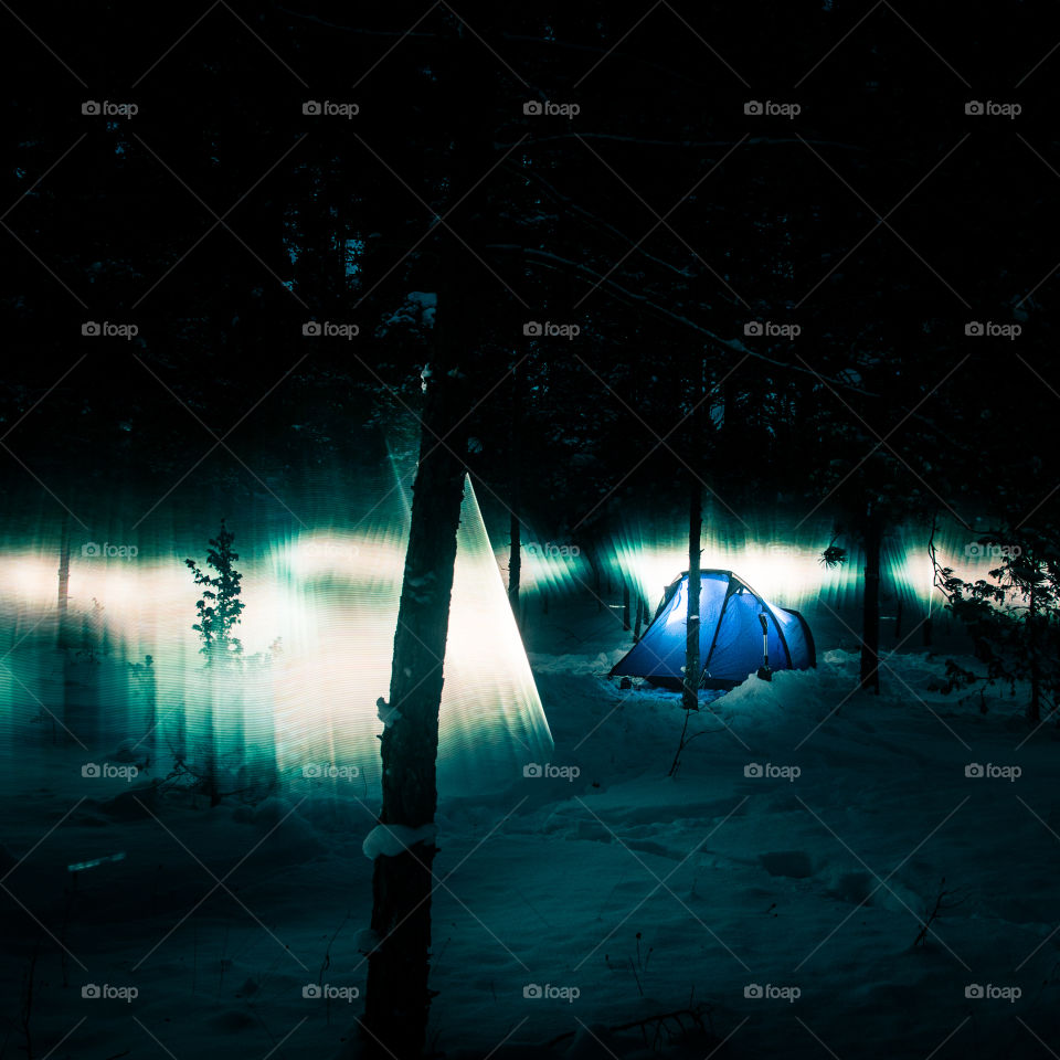 Aurora look alike in the winter forest with tent.