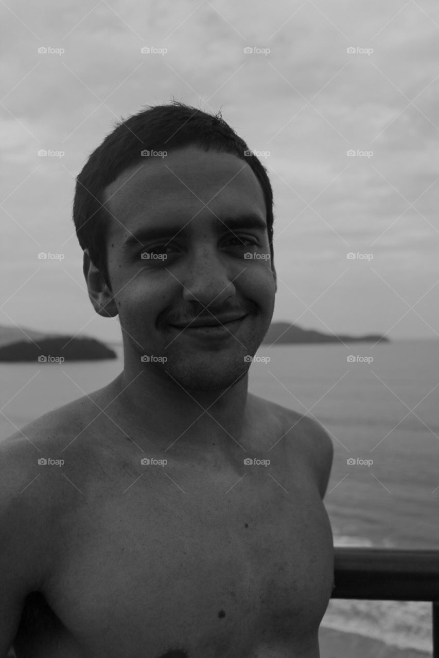 beautiful boy smiling in a beach landscape, in a black and white filter