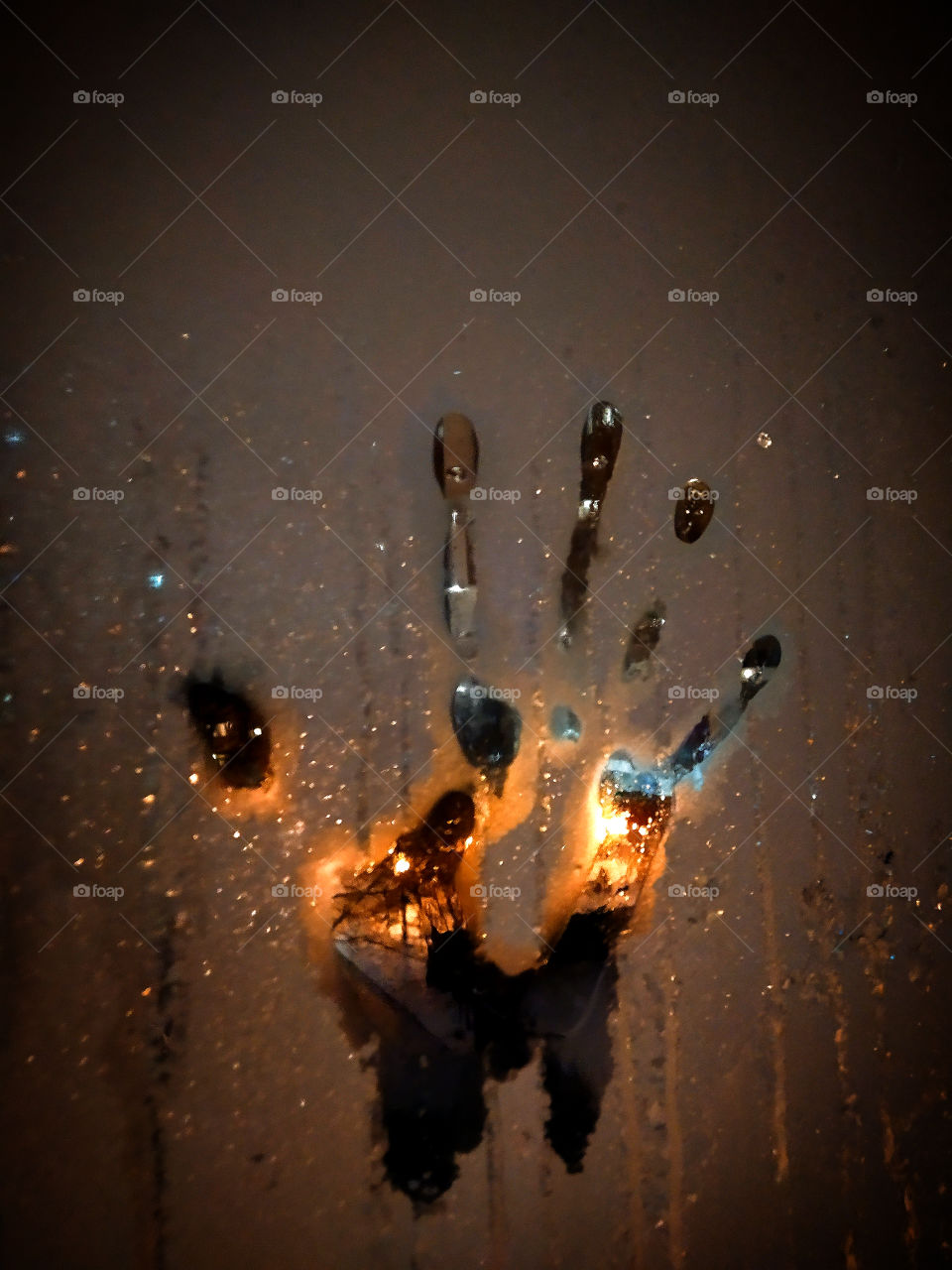 Unusual palm print on frozen glass.  Against the backdrop of the illuminated night street.  Burning palm effect