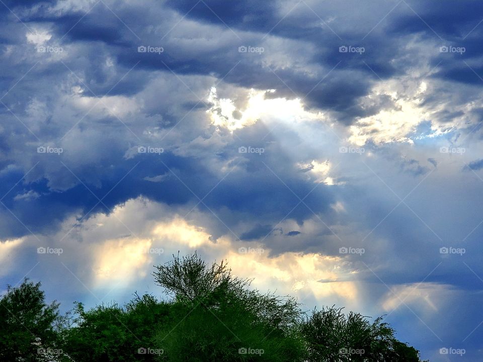 Sun beams shine through storm clouds