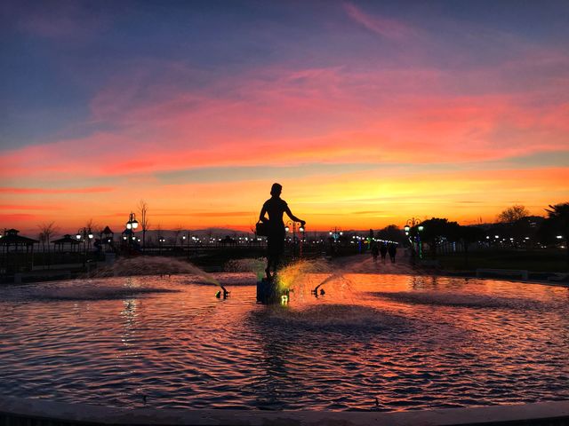 sunset with a woman statue