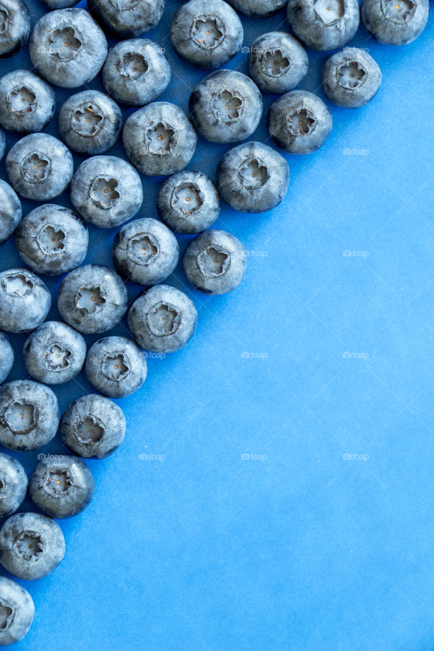 A lot of fresh blueberries on blue background. Can be used for summer, food, nutrition, healthy, lifestyle, fresh, organic themes