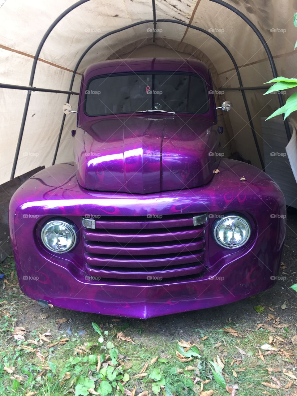 An old vintage Ford truck with a wicked paint job hidden amongst someone forest retreat in British Columbia 