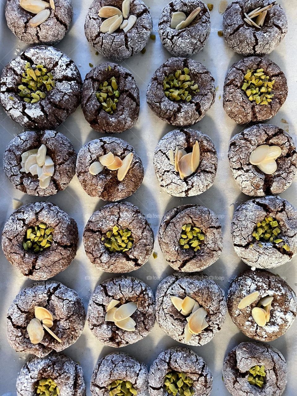 Home made chocolate pastries biscuits decorated with crumble of pistachios and almonds from above 