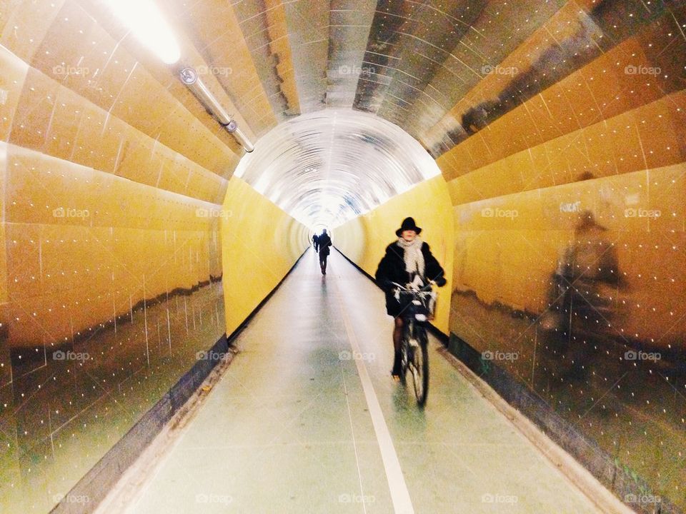 Woman riding in bicycle tunnel