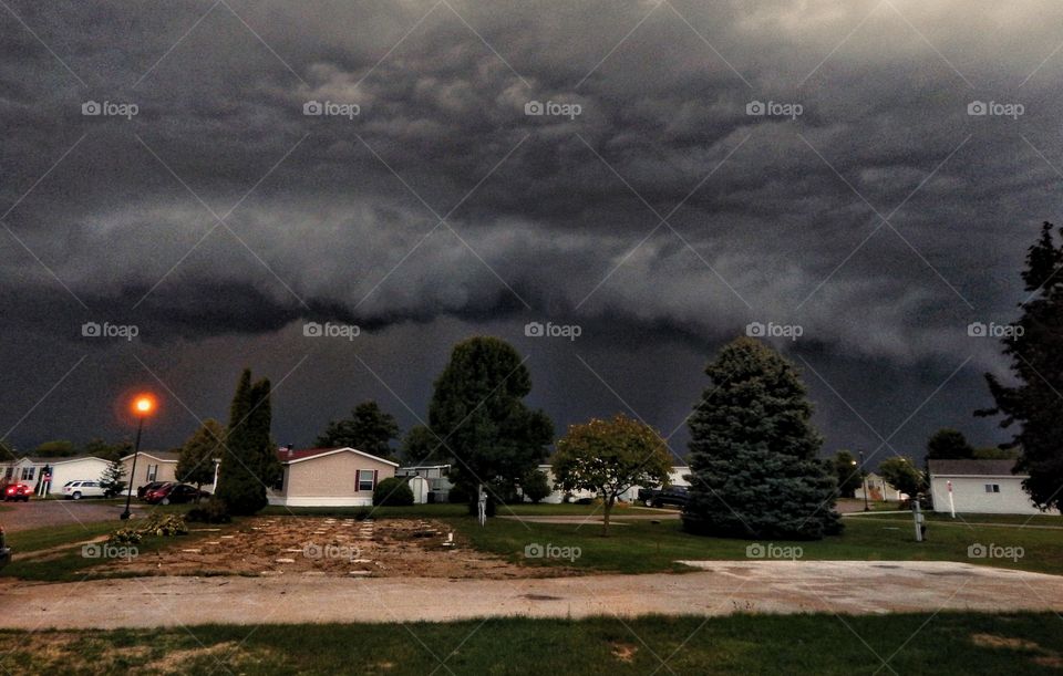 storm swirls above houses in small neighborhood