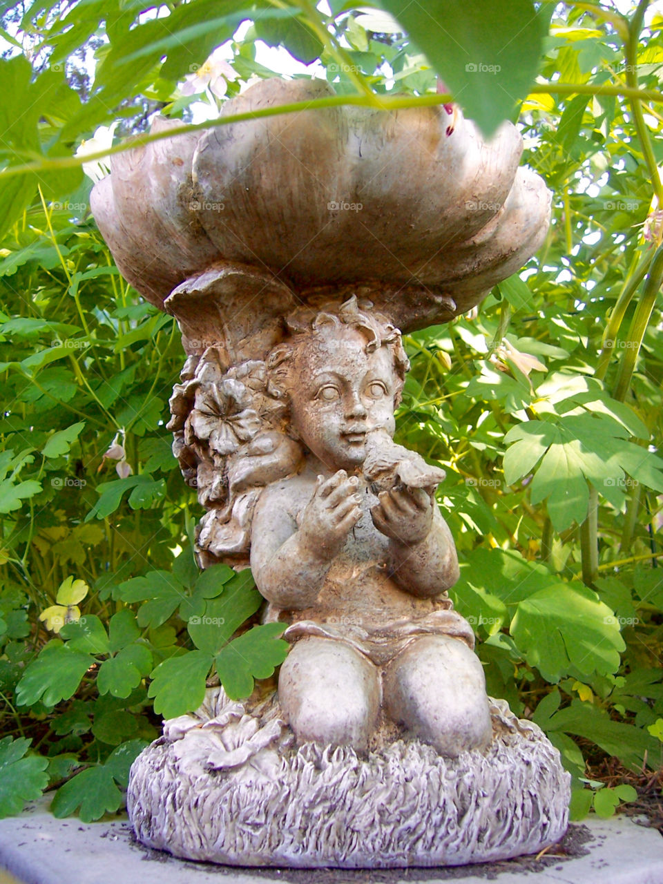 Stone garden statue in greenery