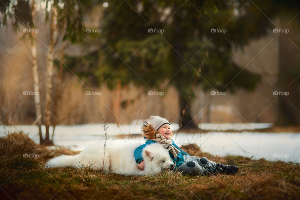 Boy with his Samoyed dog in winter park