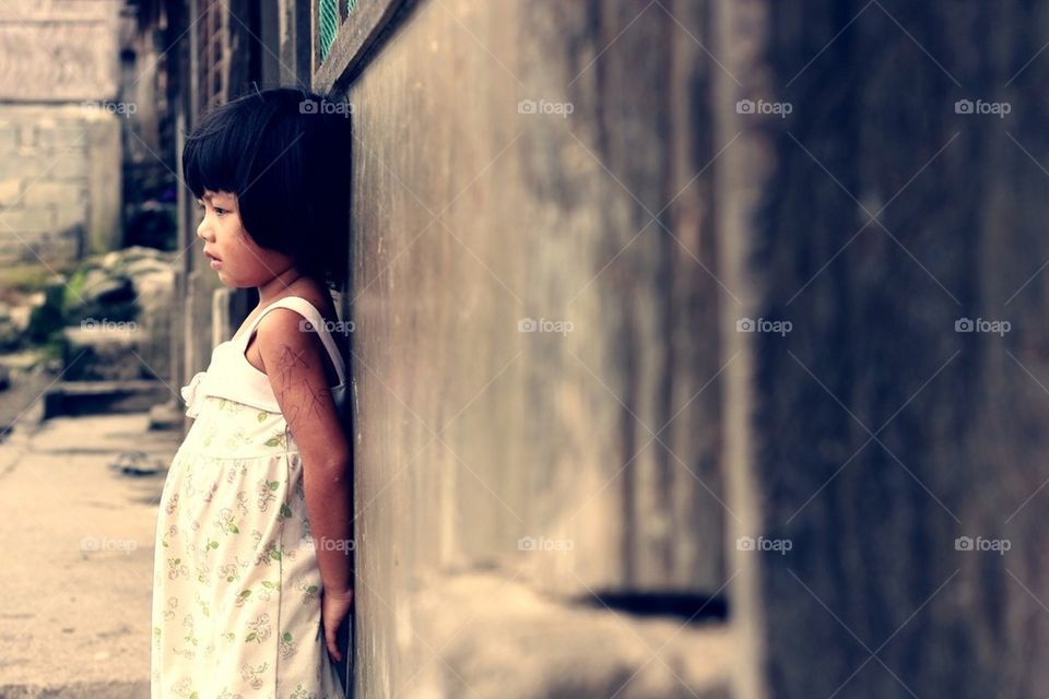 Little girl leaning on a well