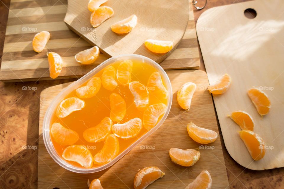 Delicious orange jelly with tangerine slices in a container and jelly worms.
