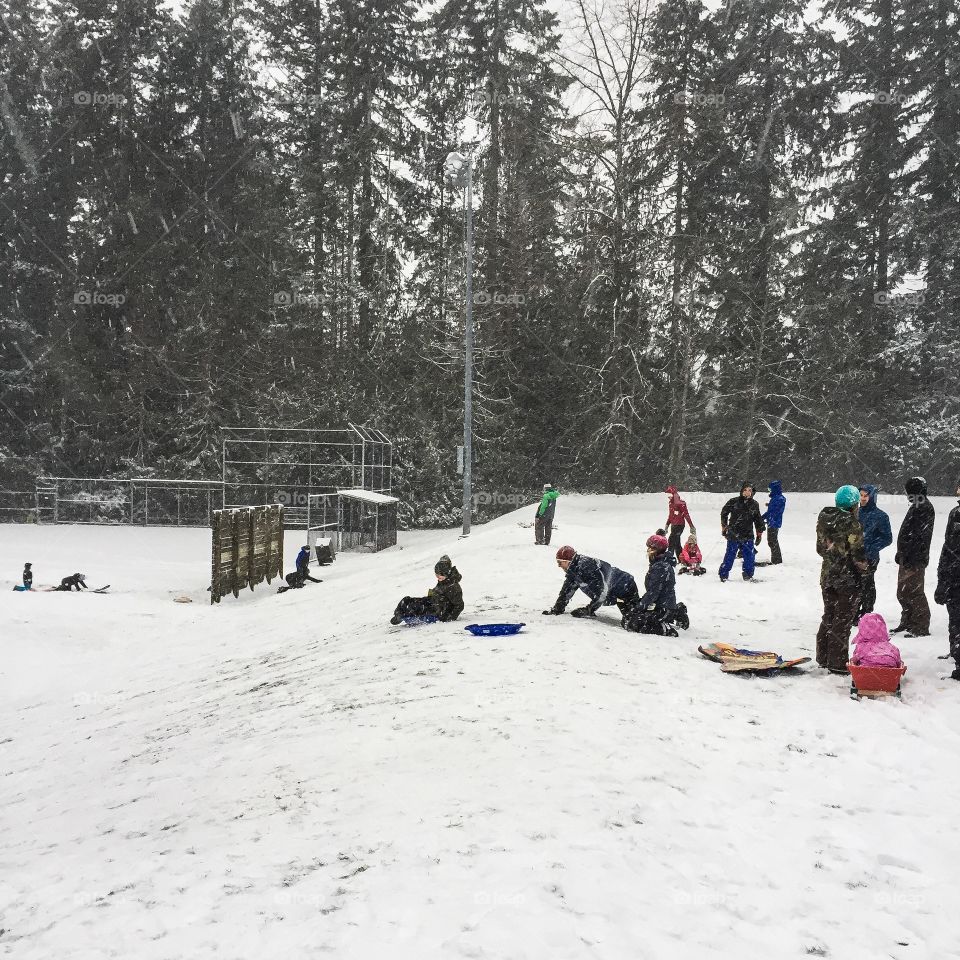 Sledding down a hill on first snowfall of winter