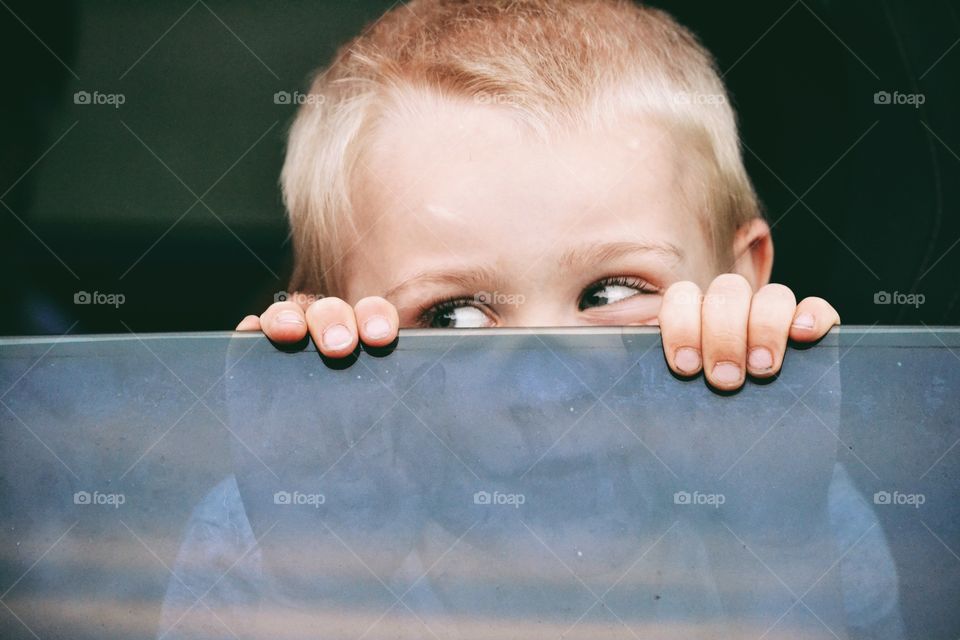 Boy looking out from a car window on a road trip