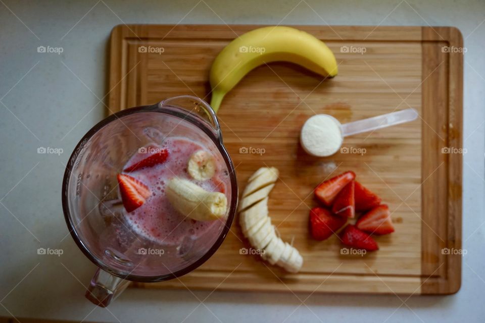 Overhead view strawberry banana smoothie ingredients in blender
