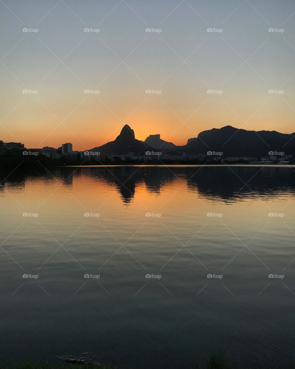 View of the Rodrigo de Freitas Lagoon, Rio de Janeiro.  It is possible to see that during the sunset the reflection of the mountains and buildings in the lake