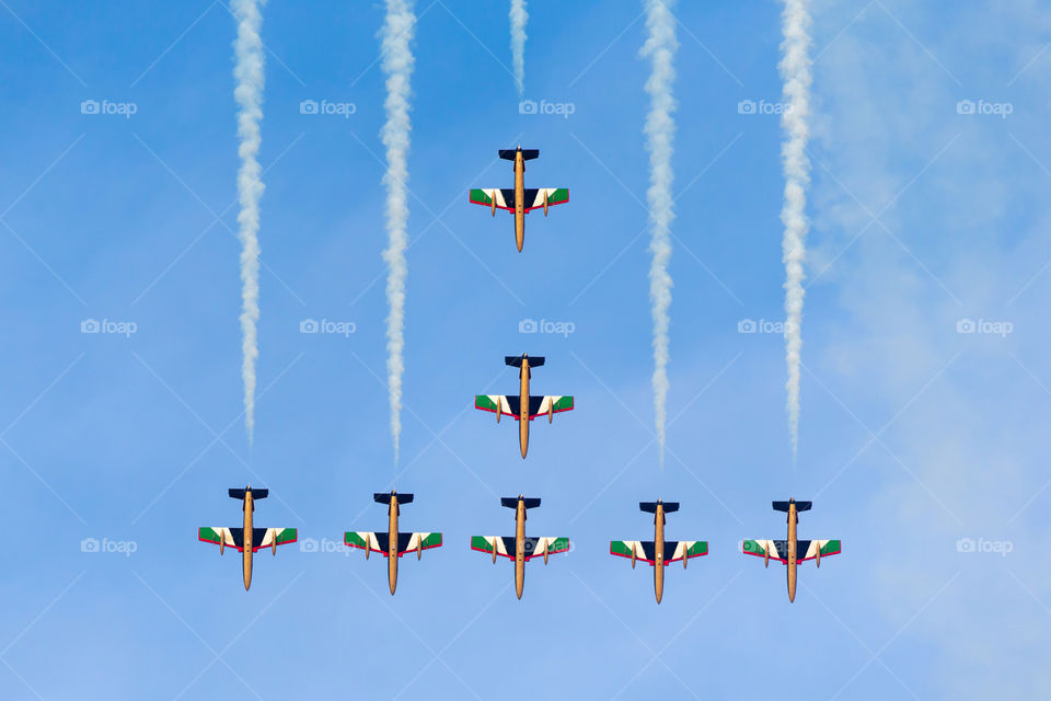 Aerobatic team flying in symmetrical formation  in the blue sky