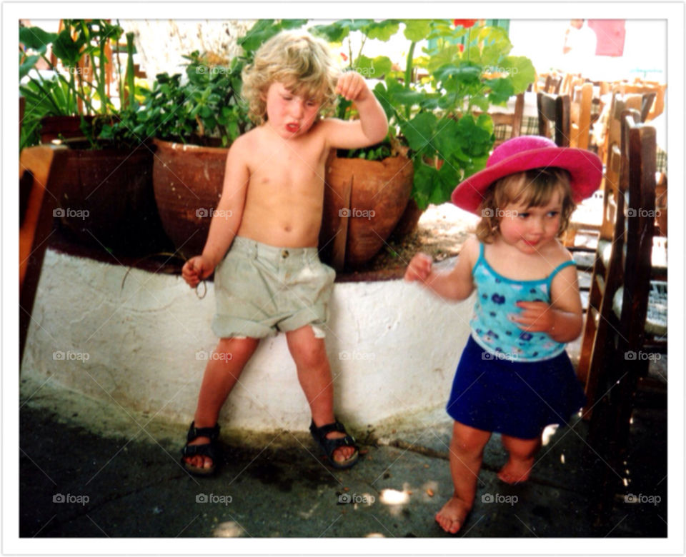 Children playing and dancing. A little boy and a girl dancing in the street of Hydra in Greece