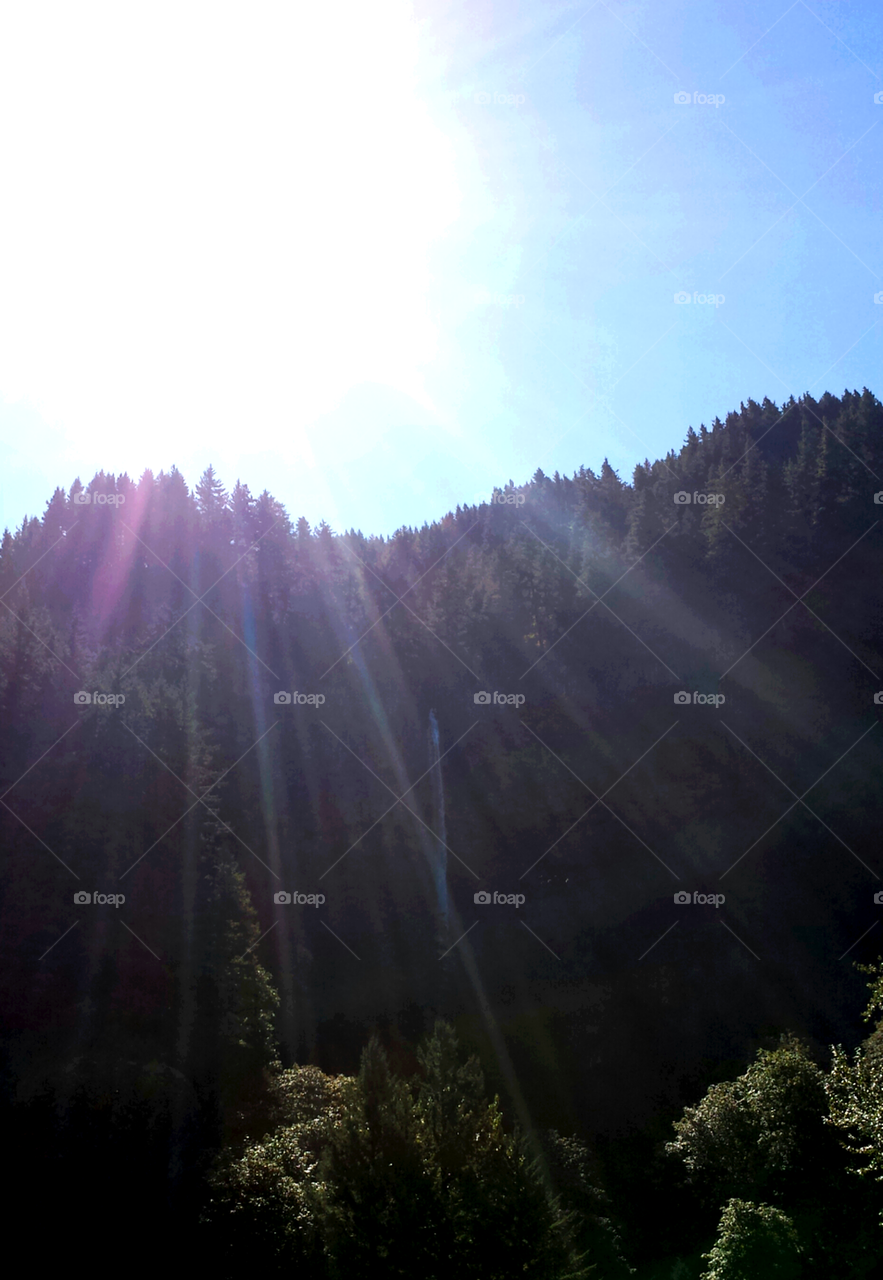 Rays of sunshine over waterfall