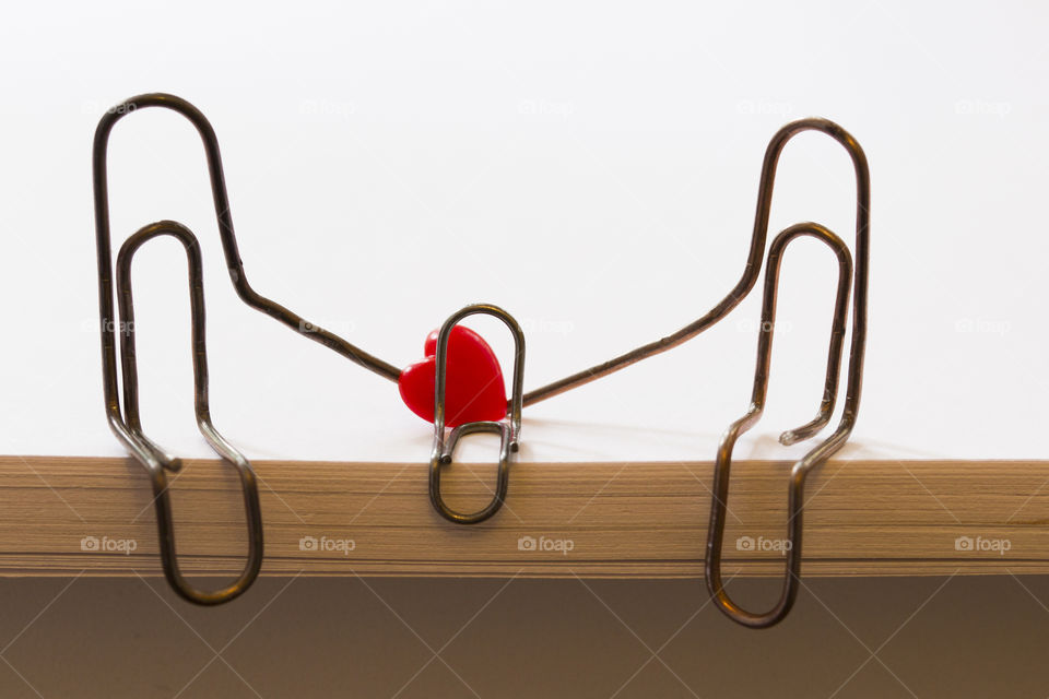 paper clips symbolizing a person sitting on a stack of white paper. family concept