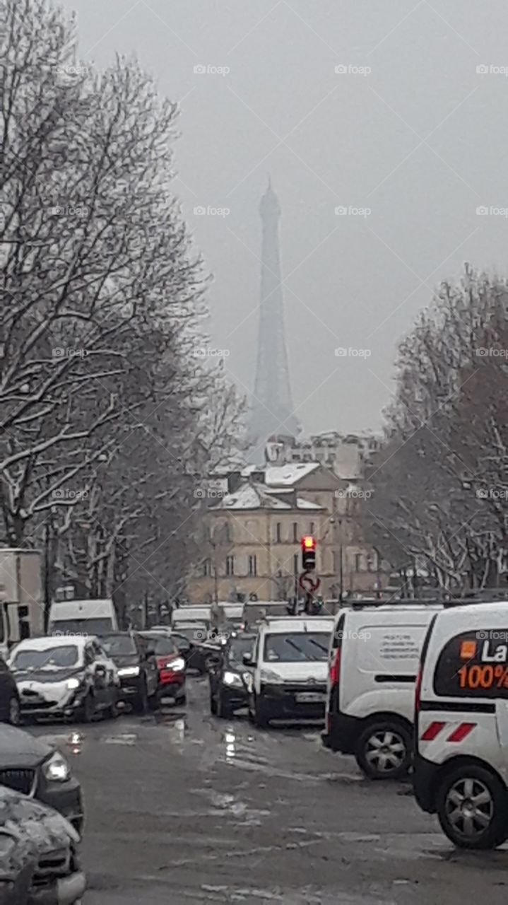 Eiffel tower and cityscape during winter snow storm of 2018. Paris, France