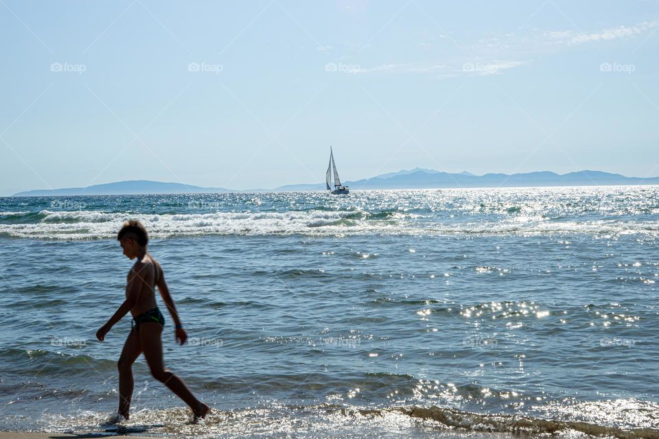 sailboat on the sea, boy on the beach