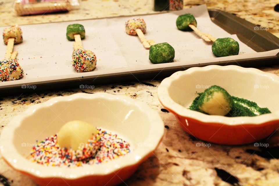 Rolling the dough in sprinkles before baking