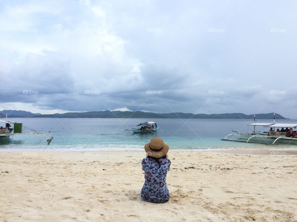 Photo of a woman sitting in front of the sea